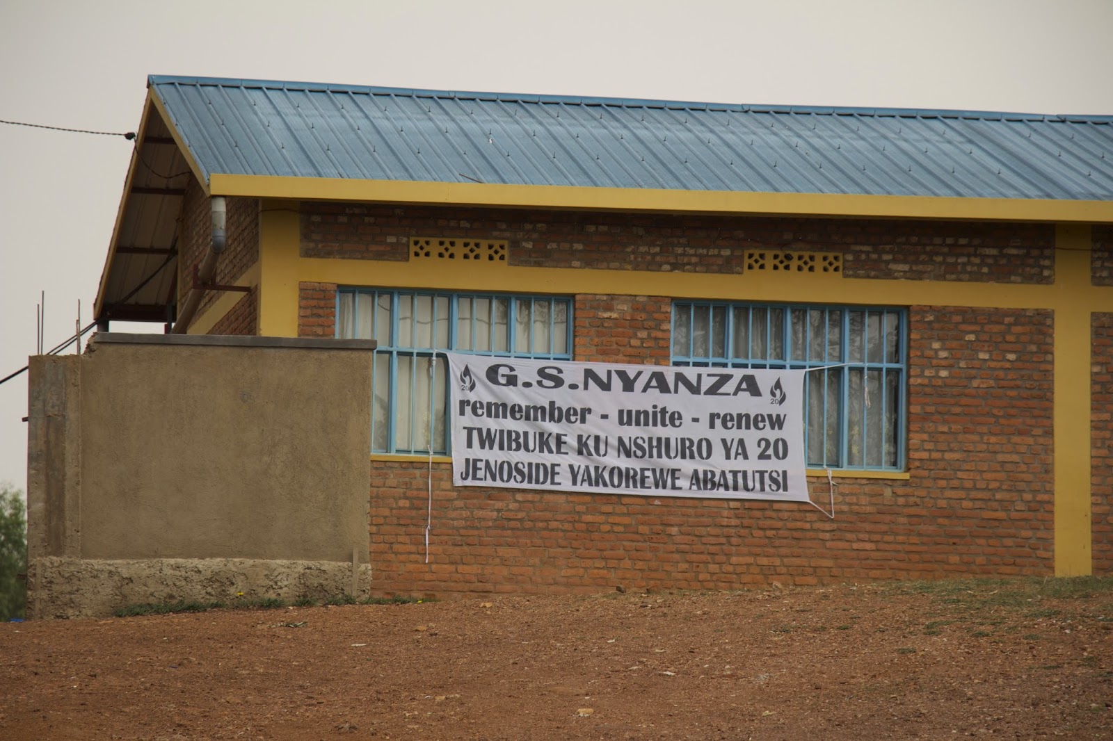 G.S. Nyanza school building with a 20th-anniversary genocide remembrance banner reading remember, unite, renew