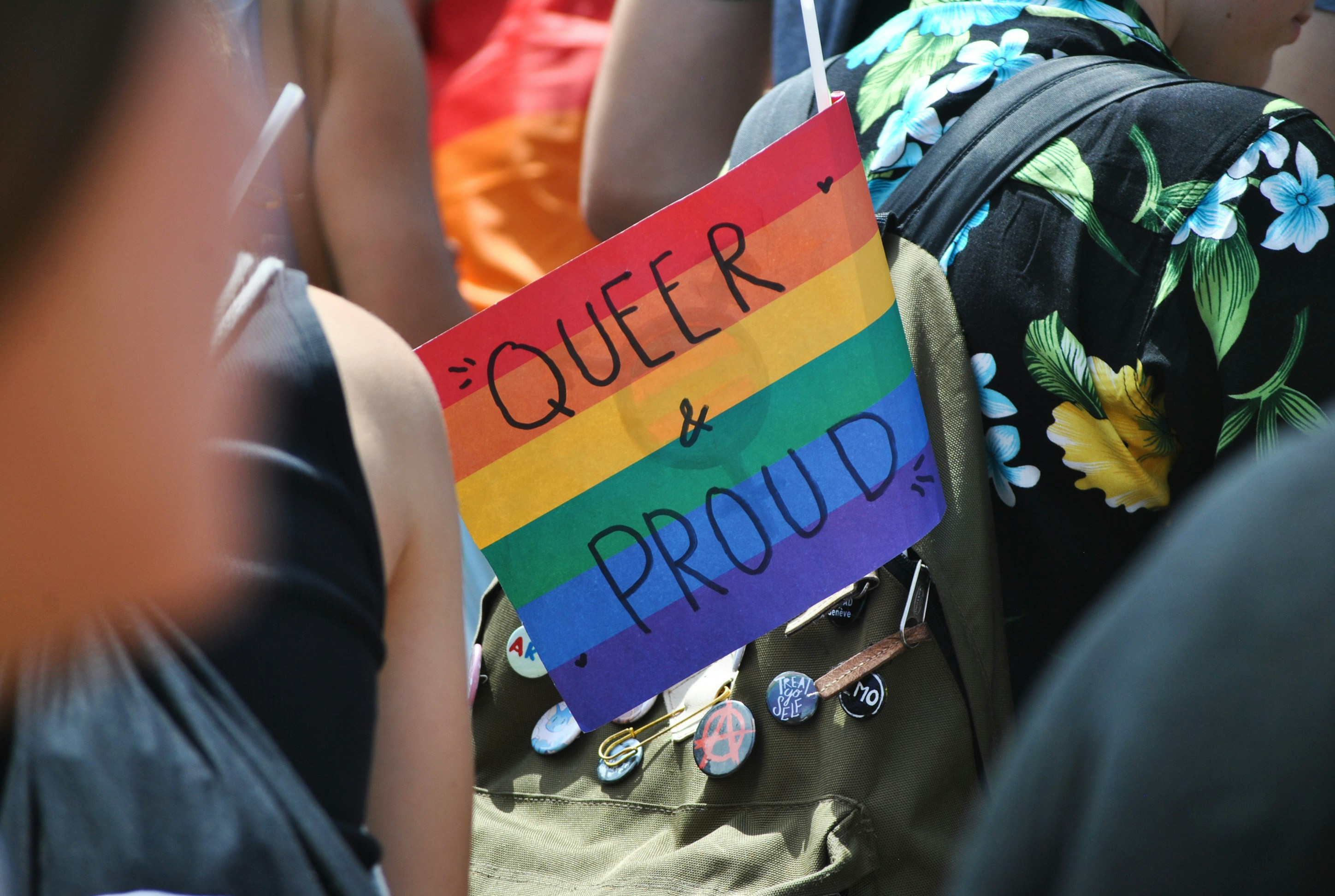 Person holding a queer pride sign at a community event