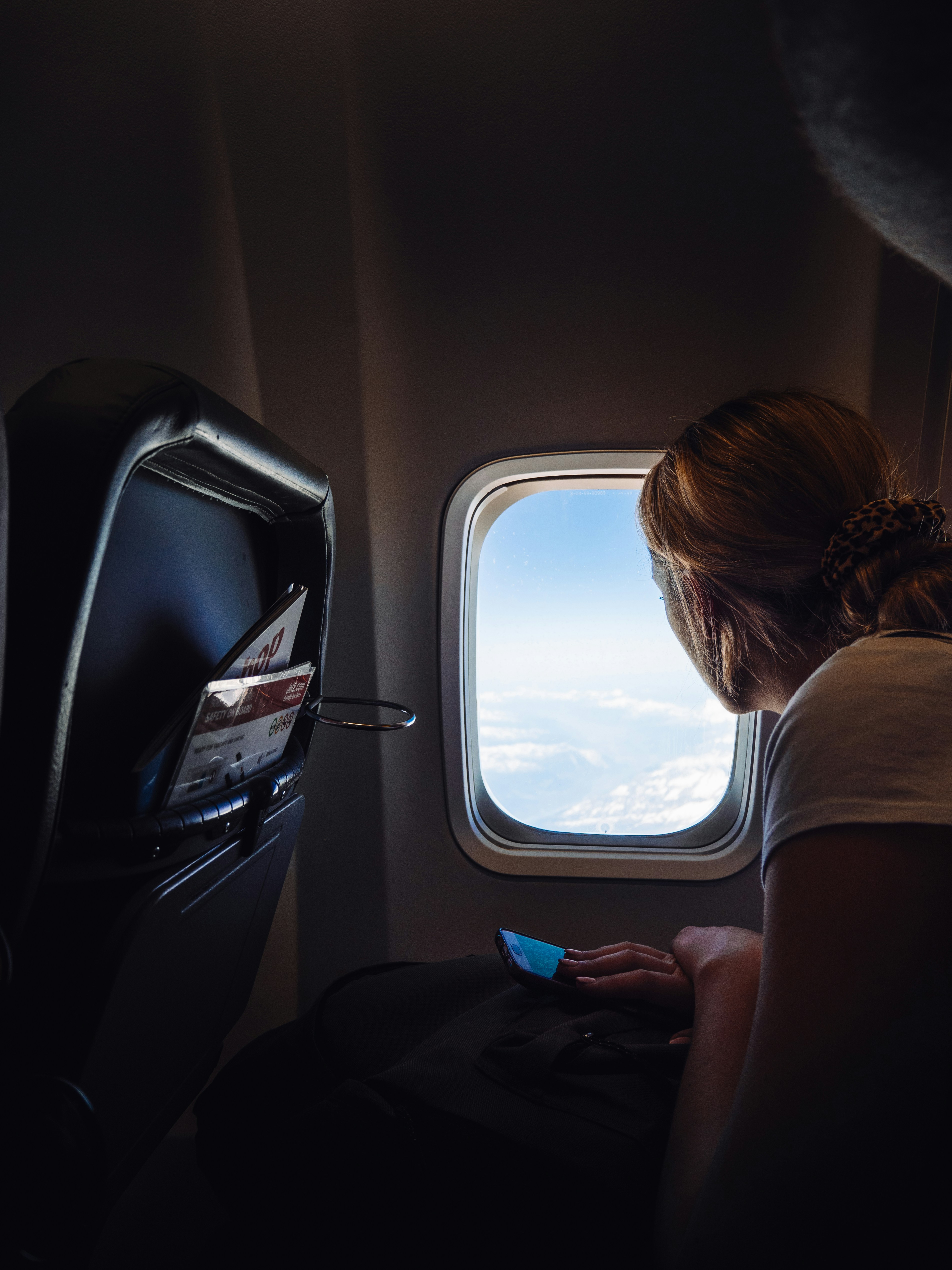 Woman gazing out an airplane window — the moment the scholarship makes possible